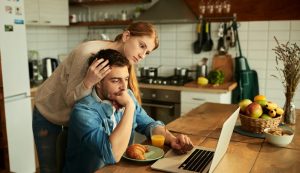 A couple look anxiously at a laptop